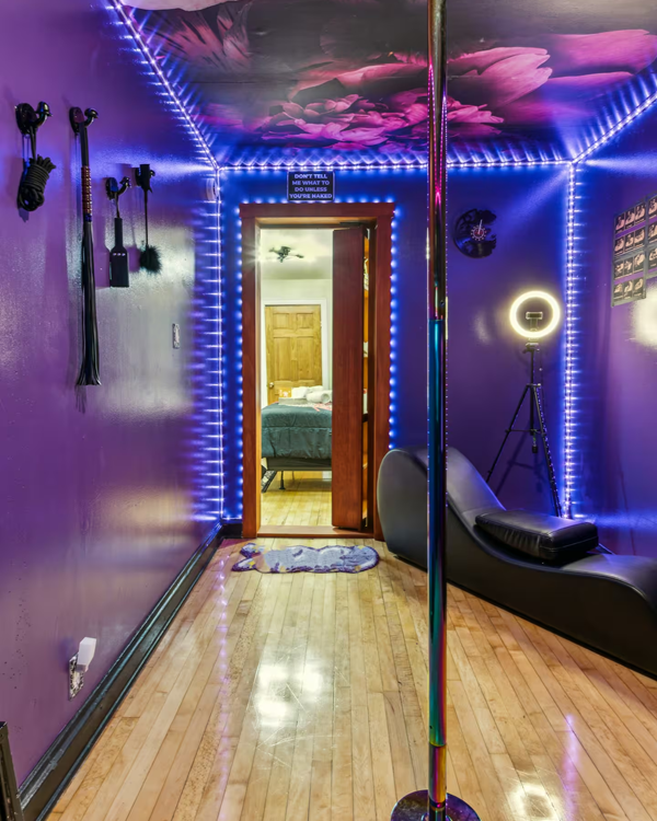 Private pole dance room in Milwaukee fantasy suite with mood lighting and mirror accents