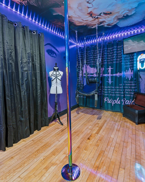 Private pole dance room in Milwaukee fantasy suite with mood lighting and mirror accents